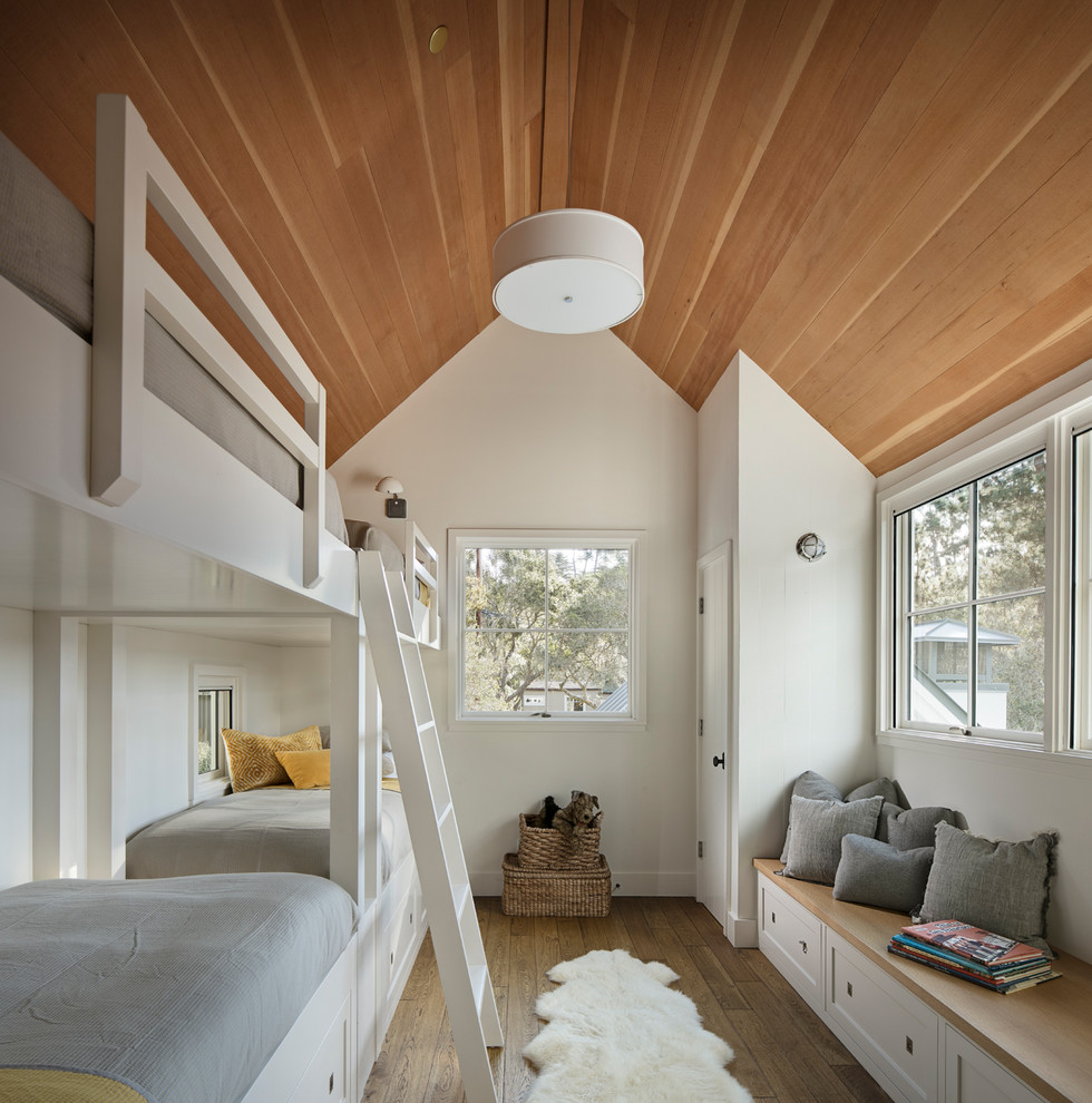 Imagen de dormitorio infantil campestre con paredes blancas, suelo de madera en tonos medios y suelo marrón