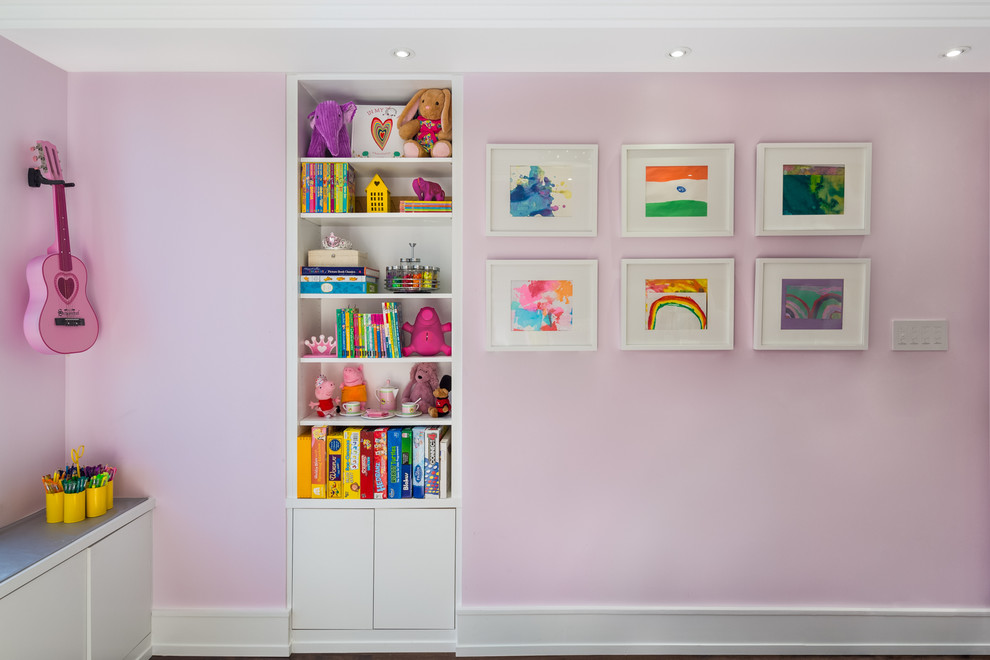 Cette image montre une grande chambre d'enfant de 4 à 10 ans traditionnelle avec un mur rose, parquet foncé et un sol marron.