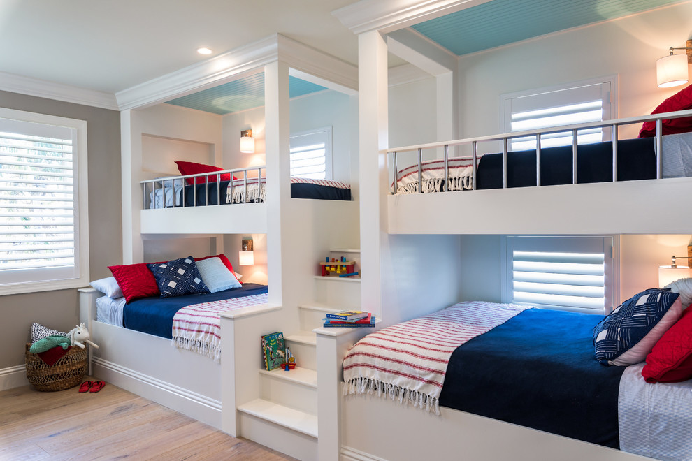 Expansive nautical gender neutral kids' bedroom in Miami with medium hardwood flooring, brown floors and grey walls.