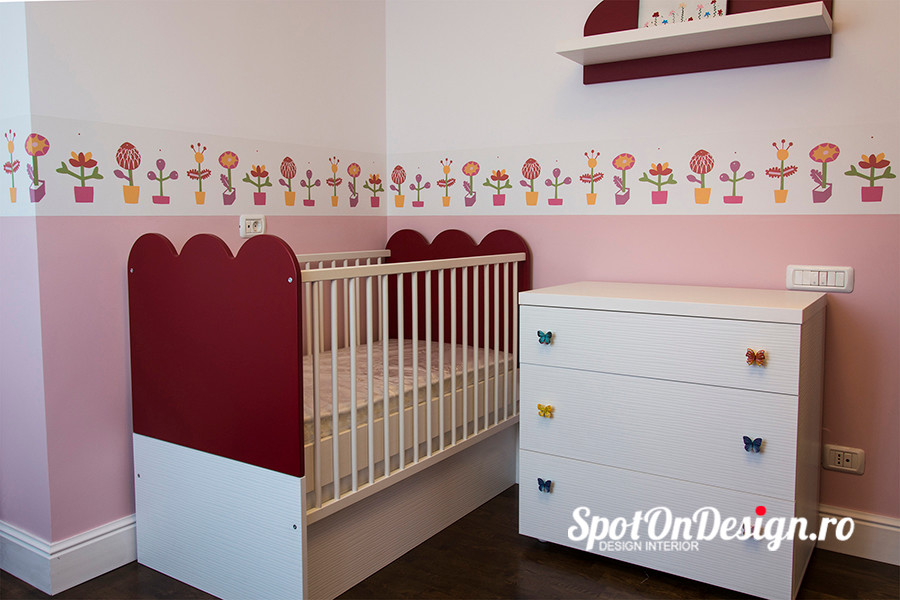 Réalisation d'une petite chambre d'enfant de 1 à 3 ans bohème avec un mur multicolore et parquet foncé.