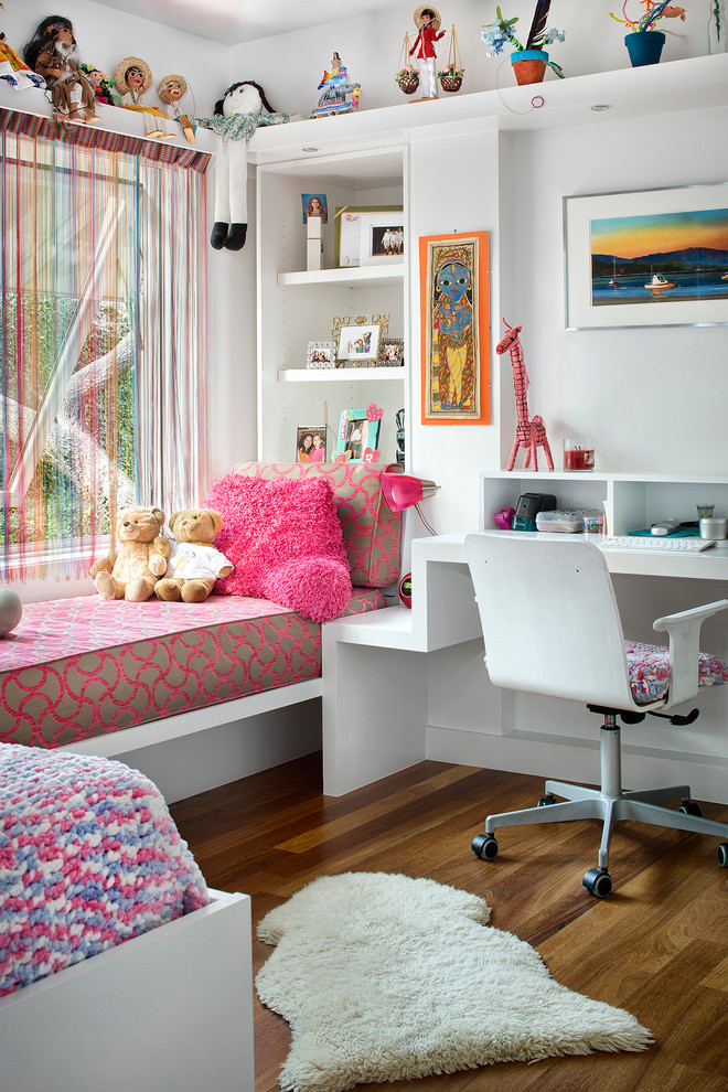Foto på ett mellanstort funkis flickrum kombinerat med sovrum och för 4-10-åringar, med vita väggar och mellanmörkt trägolv