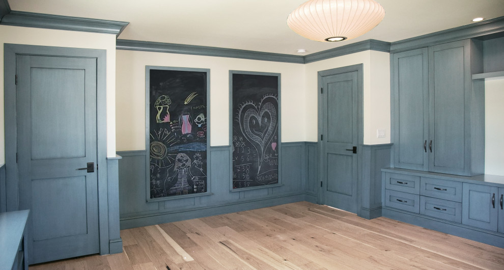 Inspiration för mellanstora klassiska könsneutrala barnrum kombinerat med lekrum, med blå väggar, mellanmörkt trägolv och brunt golv