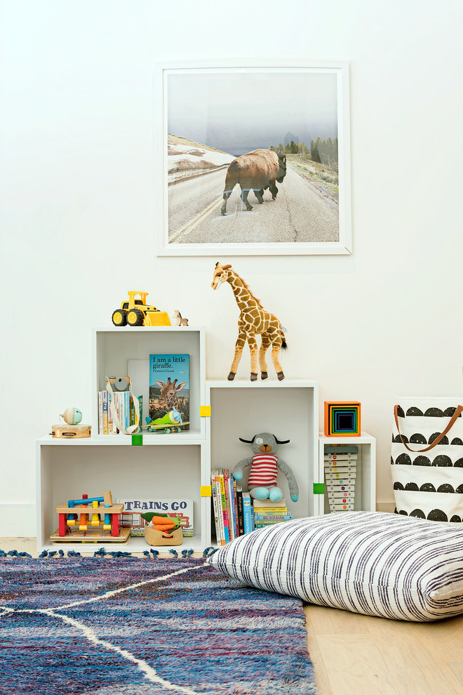 Ispirazione per una cameretta per bambini design con pareti bianche e parquet chiaro