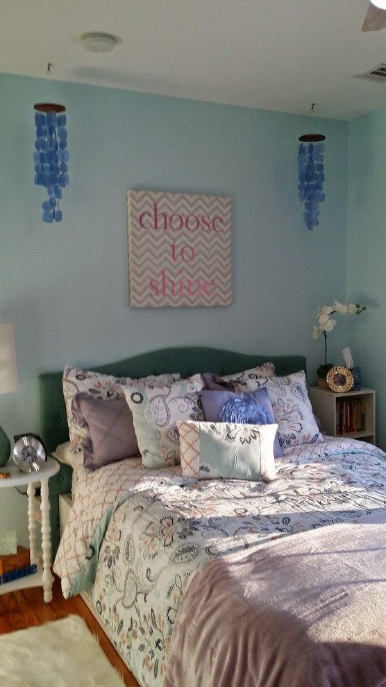 Exemple d'une petite chambre d'enfant chic avec un mur bleu et un sol en bois brun.