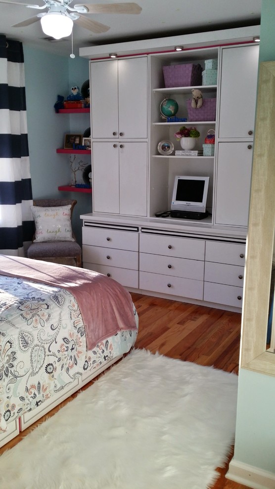 Inspiration för små klassiska barnrum kombinerat med sovrum, med blå väggar och mellanmörkt trägolv