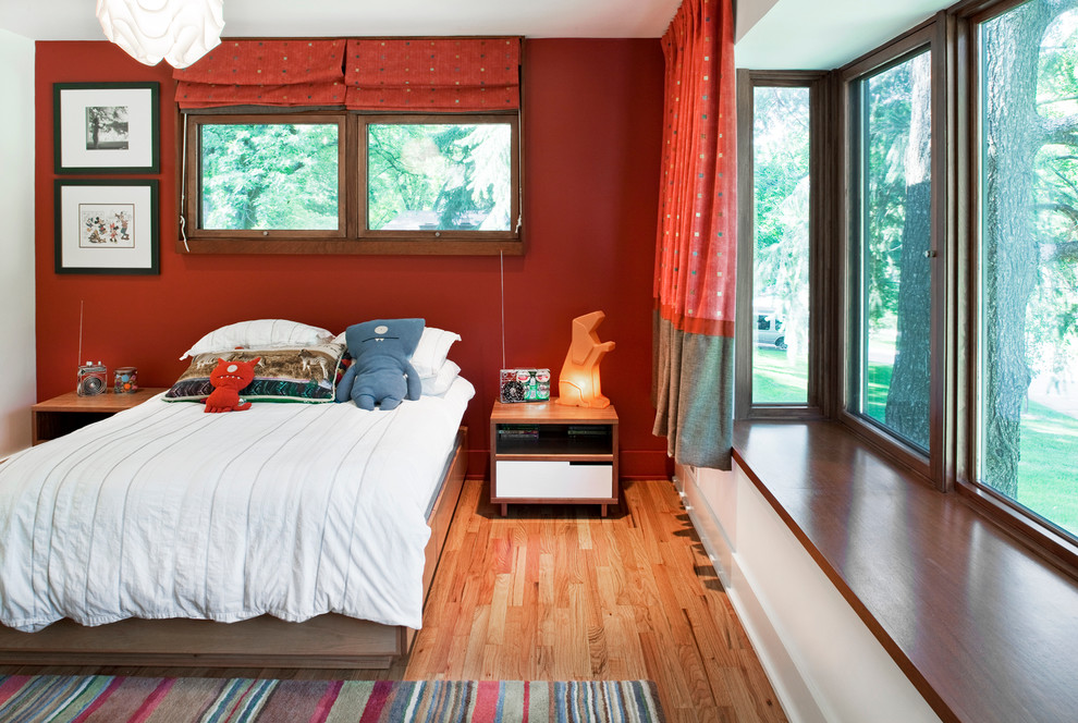 Diseño de dormitorio infantil de 4 a 10 años actual con paredes rojas y suelo de madera en tonos medios