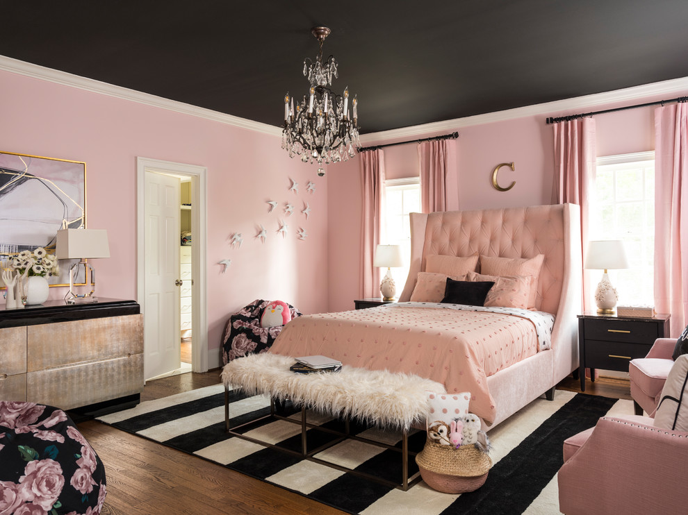 Inredning av ett klassiskt barnrum kombinerat med sovrum, med rosa väggar och mörkt trägolv