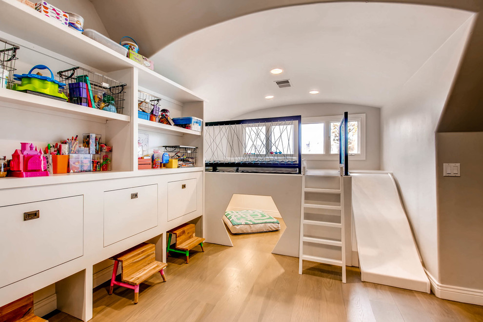 Ispirazione per una grande cameretta per bambini da 1 a 3 anni design con pareti grigie, pavimento in legno massello medio e pavimento marrone