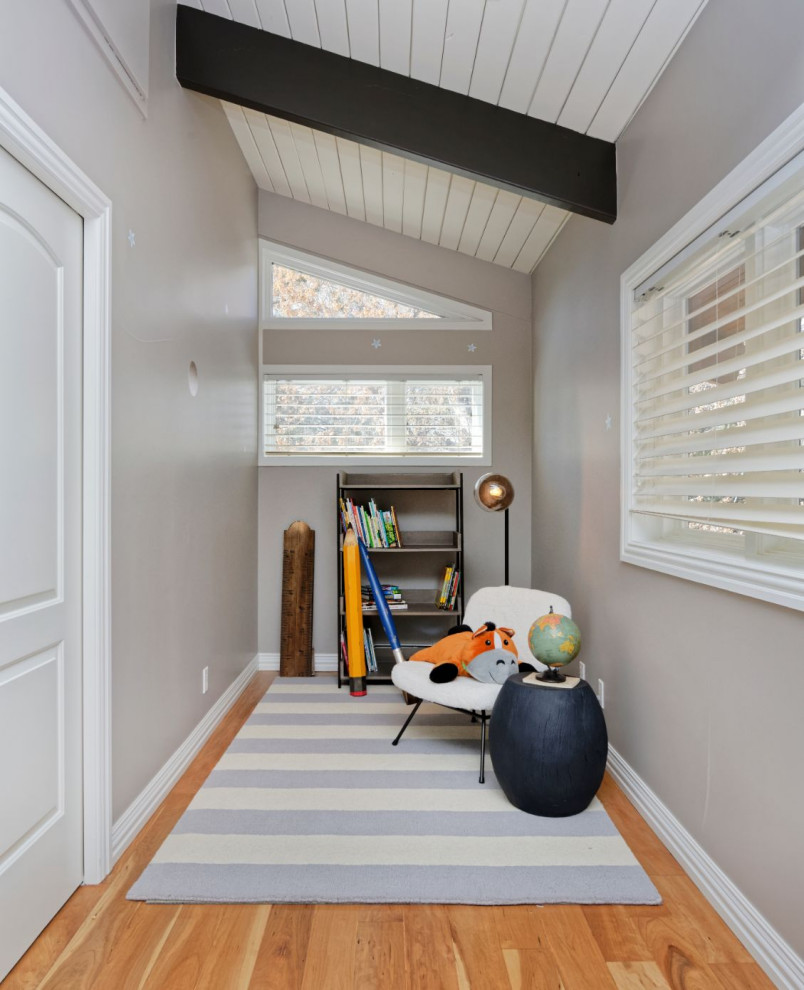 Idée de décoration pour une chambre d'enfant design de taille moyenne avec un bureau, un mur beige et un sol en bois brun.