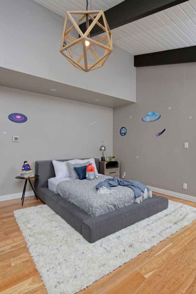Foto på ett mellanstort funkis pojkrum kombinerat med sovrum, med beige väggar och mellanmörkt trägolv