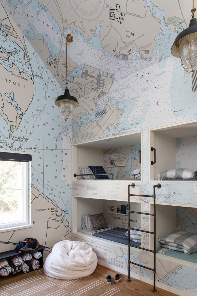 Modelo de dormitorio infantil marinero con paredes multicolor, suelo de madera en tonos medios, suelo marrón y papel pintado