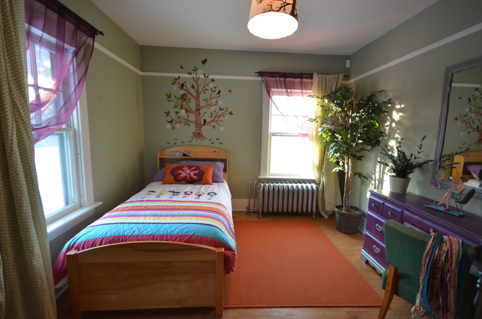 Modelo de dormitorio infantil de 4 a 10 años bohemio con paredes verdes y suelo de madera en tonos medios
