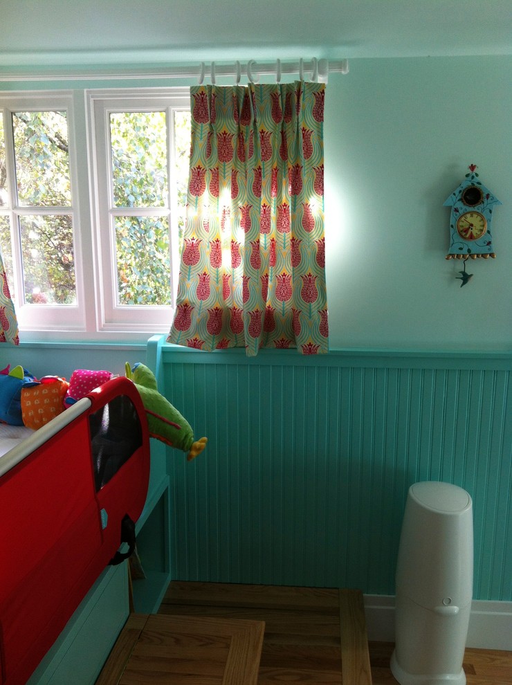 Ispirazione per una cameretta per bambini da 4 a 10 anni stile americano di medie dimensioni con pareti blu e pavimento in legno massello medio