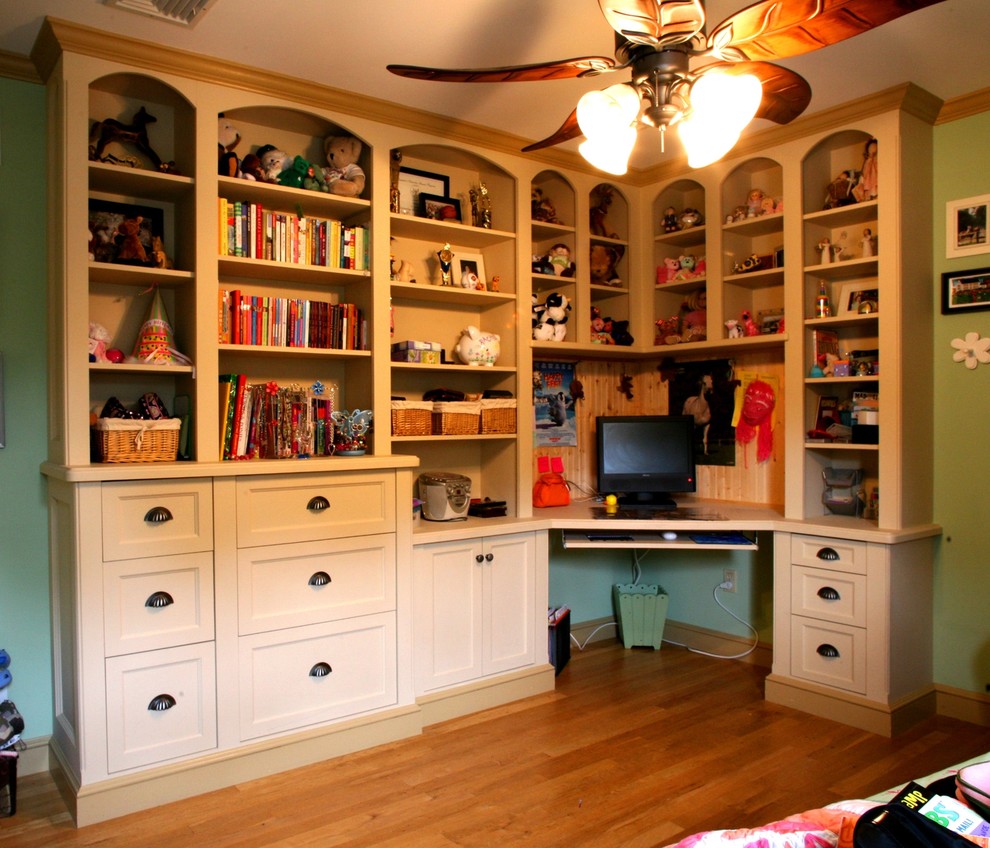 This is an example of a traditional gender neutral kids' study space in New York with green walls.