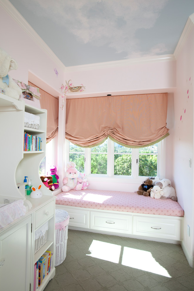 Cette image montre une grande chambre d'enfant traditionnelle avec un mur rose et moquette.