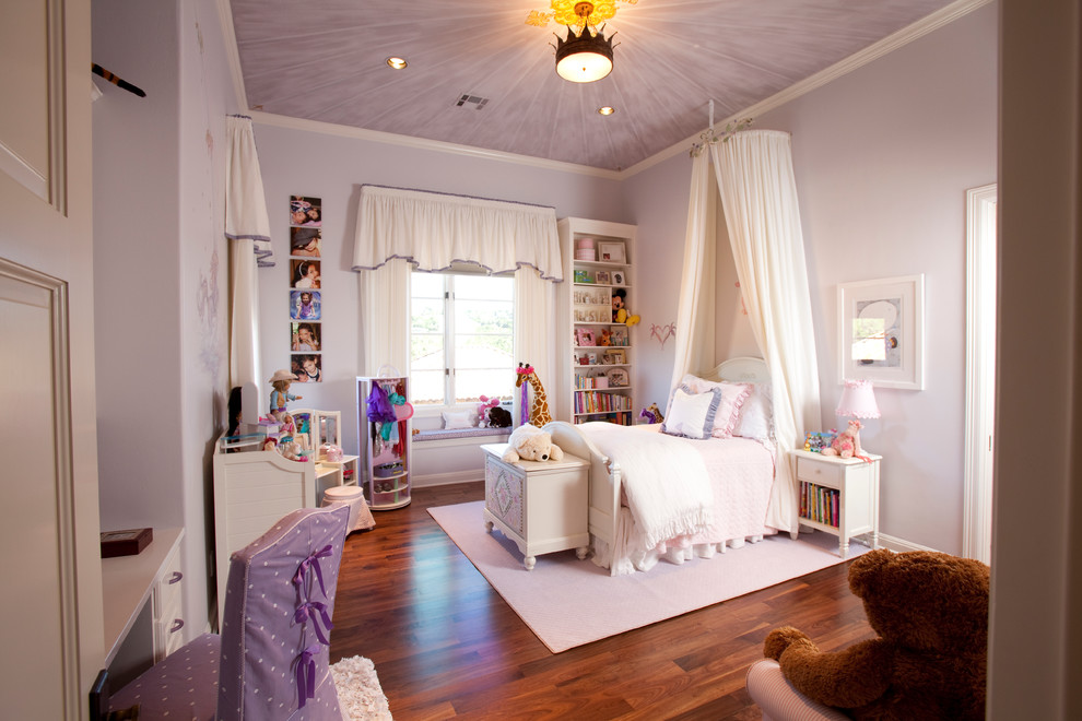 Immagine di una cameretta per bambini da 4 a 10 anni classica di medie dimensioni con pareti viola e pavimento in legno massello medio