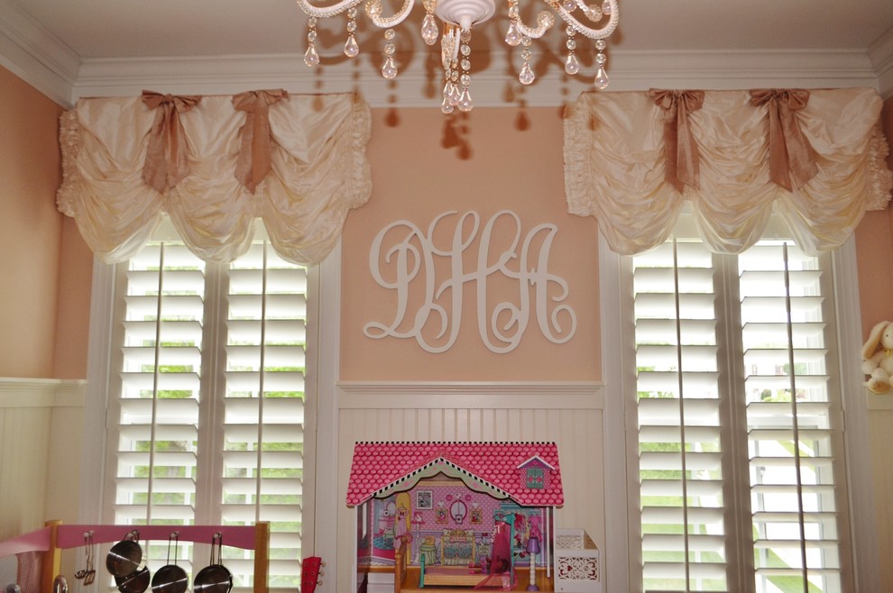 Immagine di una cameretta per bambini da 1 a 3 anni tradizionale con pareti rosa e parquet scuro