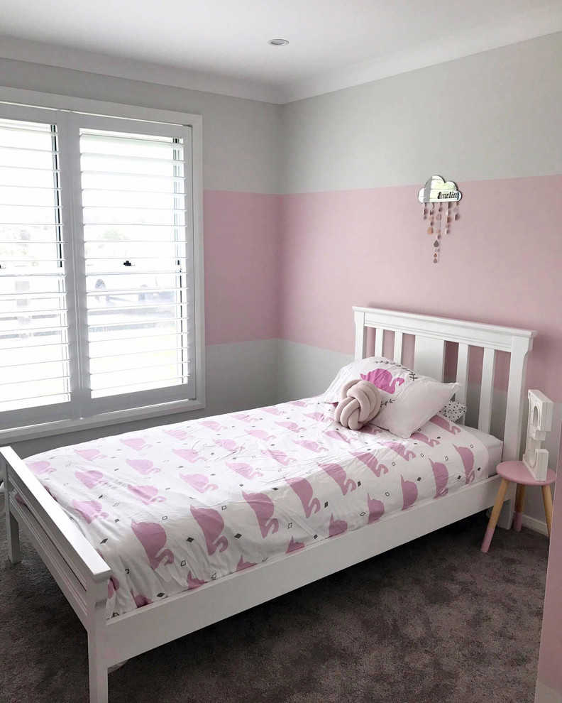 Idée de décoration pour une chambre d'enfant de 4 à 10 ans design de taille moyenne avec un mur rose et moquette.