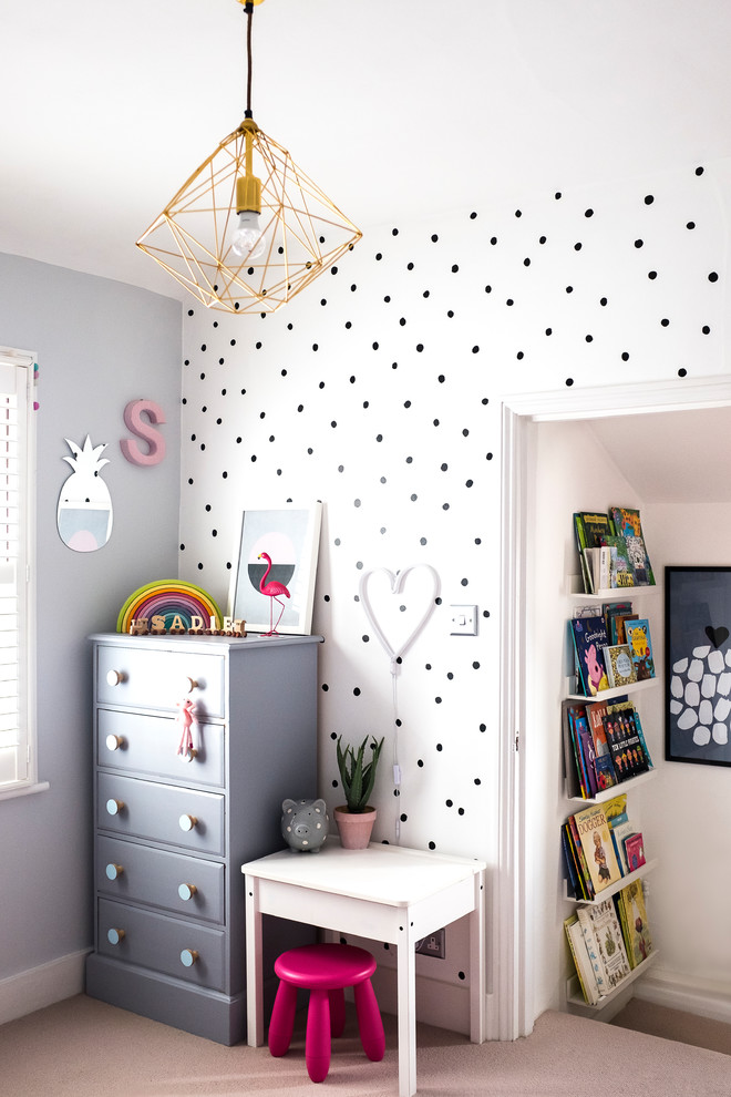 Small contemporary toddler’s room for girls in London with grey walls, carpet and grey floors.