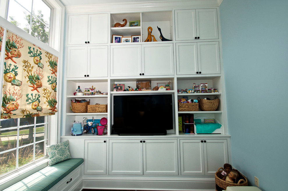 This is an example of a medium sized nautical kids' bedroom for girls in New York with blue walls and dark hardwood flooring.