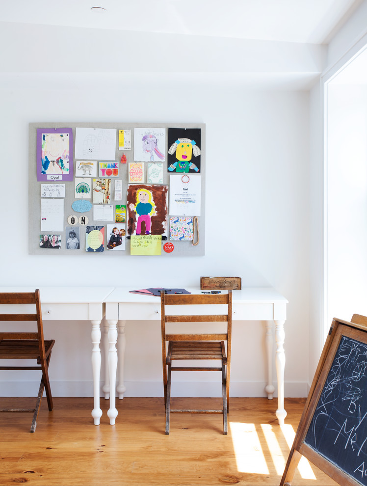 Imagen de habitación infantil unisex de 4 a 10 años actual grande con escritorio, paredes blancas y suelo de madera en tonos medios