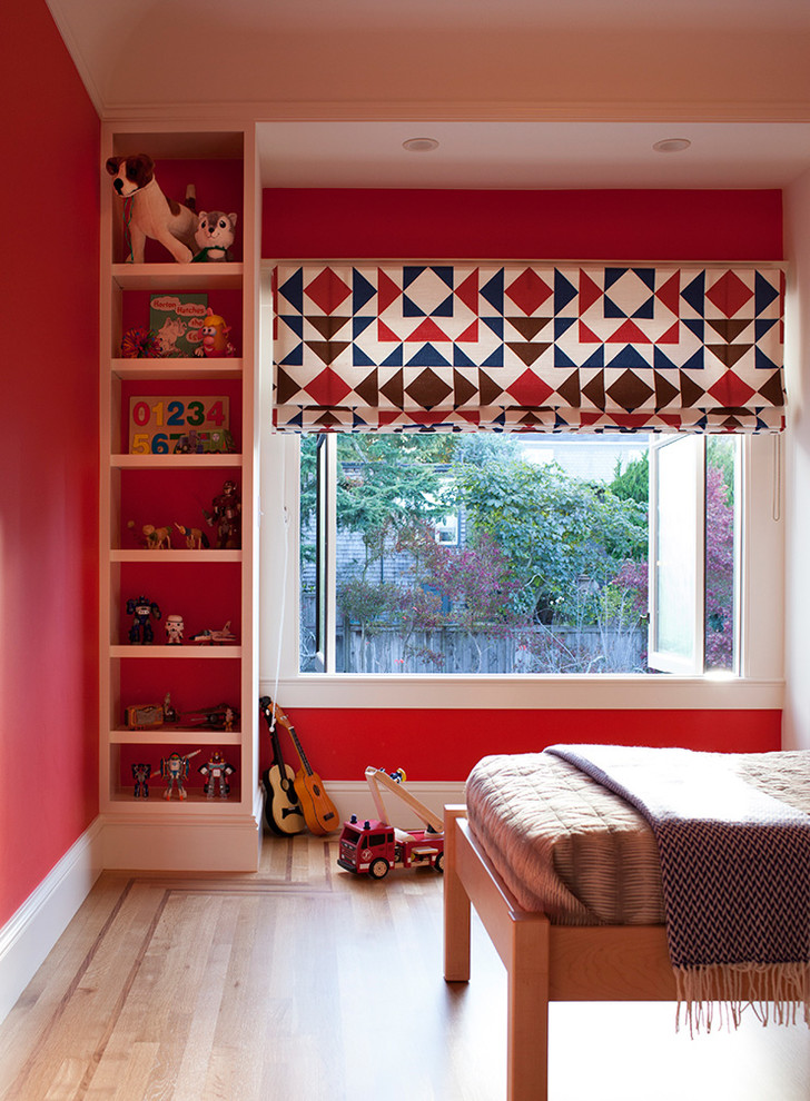 Photo of a medium sized eclectic children’s room for boys in San Francisco with red walls, light hardwood flooring and brown floors.