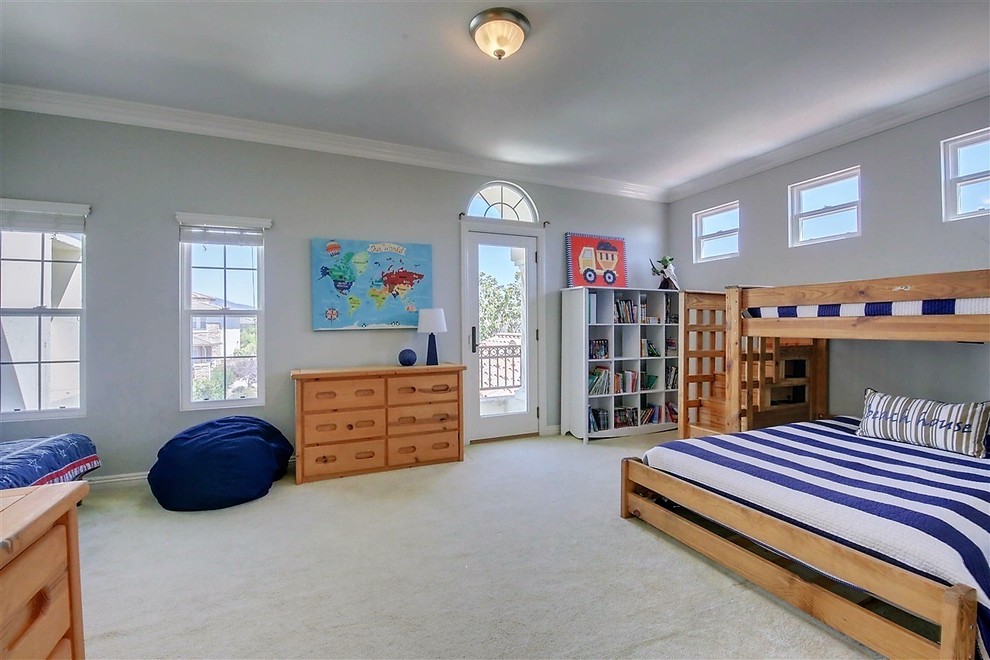 Modelo de dormitorio infantil costero grande con paredes azules, moqueta y suelo beige
