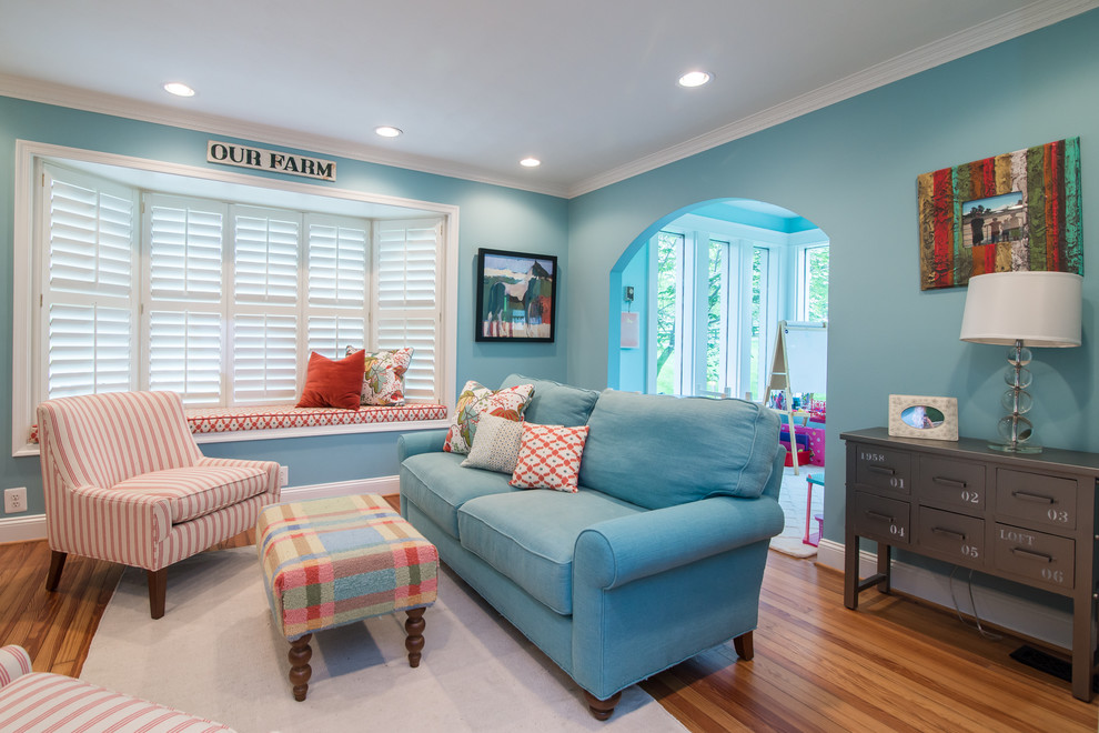 Immagine di una cameretta per bambini da 4 a 10 anni classica con pareti blu e pavimento in legno massello medio