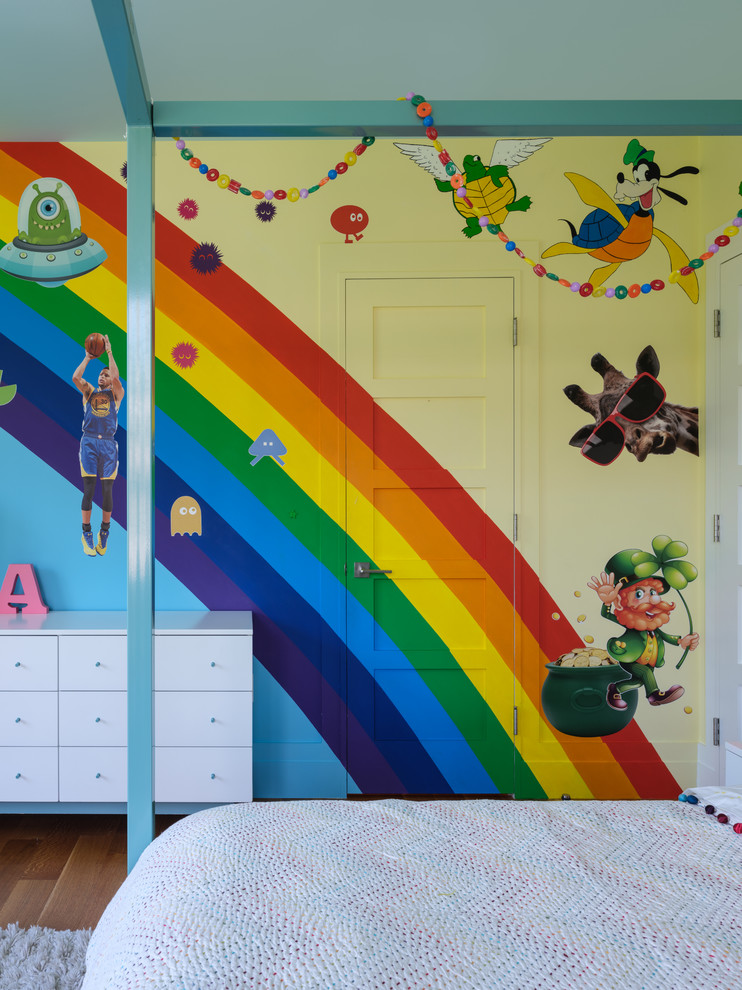 Aménagement d'une chambre d'enfant contemporaine avec un mur multicolore, un sol en bois brun et un sol marron.