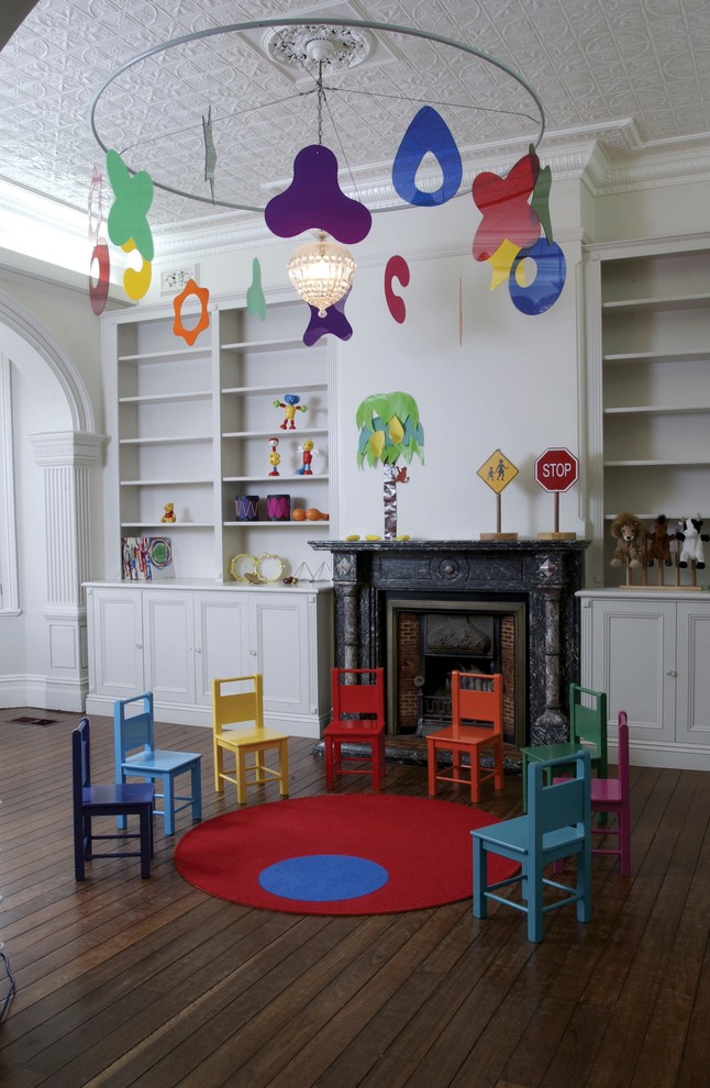 Idéer för ett modernt könsneutralt småbarnsrum kombinerat med lekrum, med vita väggar och mörkt trägolv