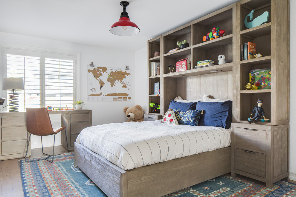 This is an example of a medium sized classic children’s room for boys in Orange County with medium hardwood flooring, white walls and beige floors.