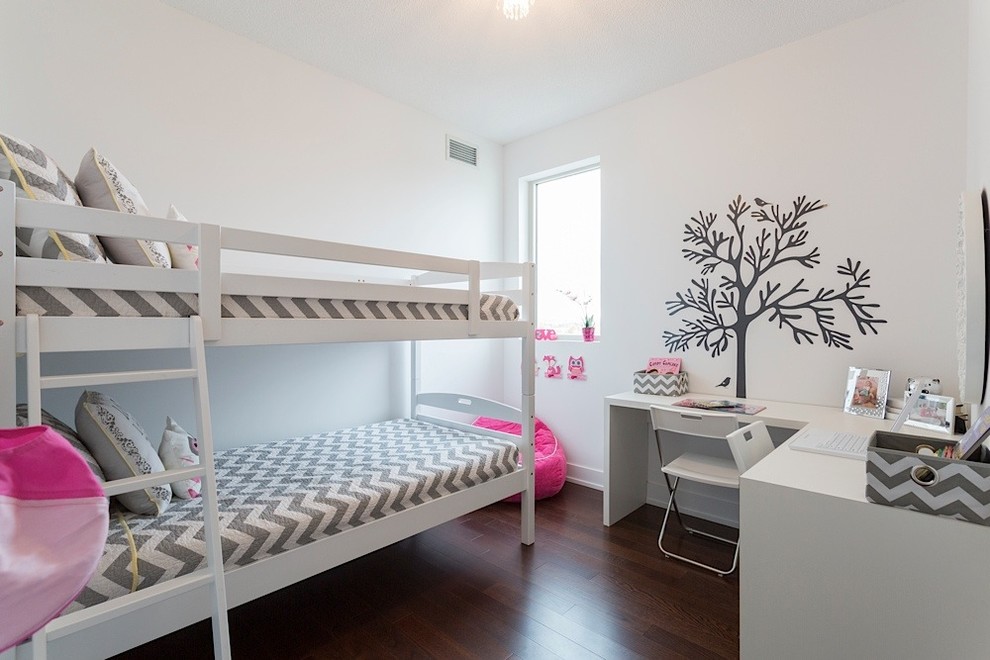 Small traditional children’s room for girls in Toronto with white walls and dark hardwood flooring.
