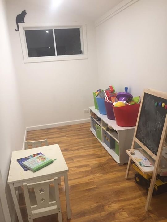 Modelo de dormitorio infantil de 1 a 3 años contemporáneo pequeño con paredes blancas y suelo de madera en tonos medios