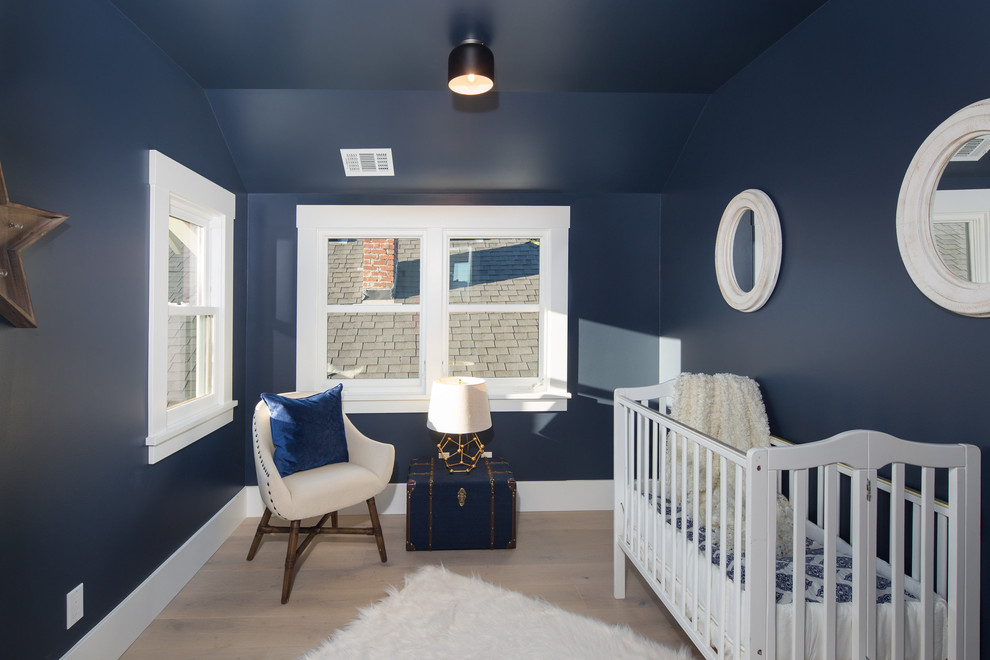 Réalisation d'une petite chambre d'enfant design avec un mur bleu et parquet clair.