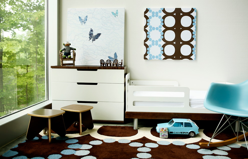 Пример оригинального дизайна: нейтральная детская в современном стиле с спальным местом, белыми стенами и ковровым покрытием для ребенка от 1 до 3 лет