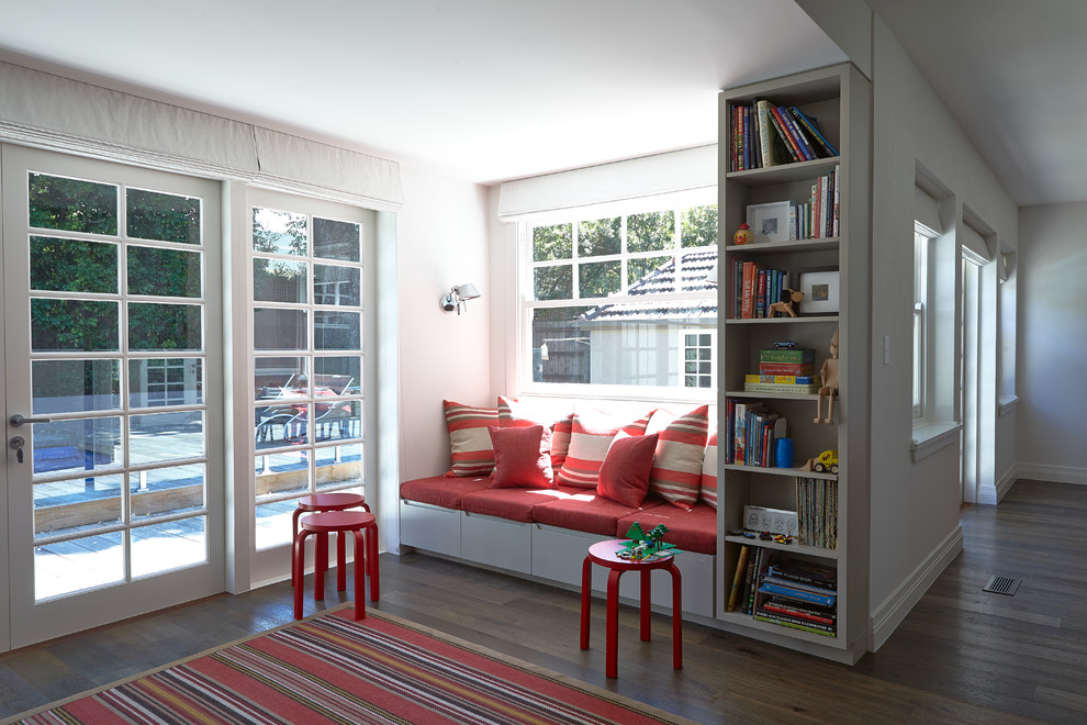 Modelo de dormitorio infantil de 4 a 10 años actual de tamaño medio con paredes blancas y suelo de madera en tonos medios