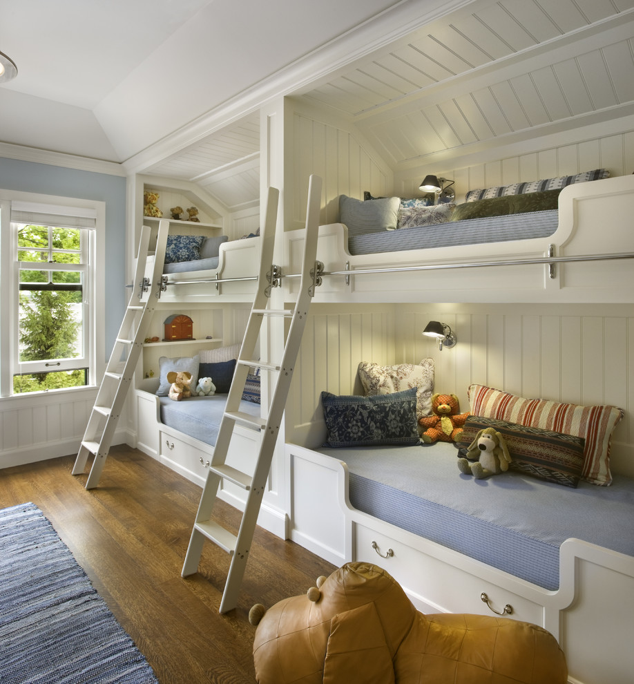Elegant gender-neutral medium tone wood floor kids' room photo in Chicago with blue walls