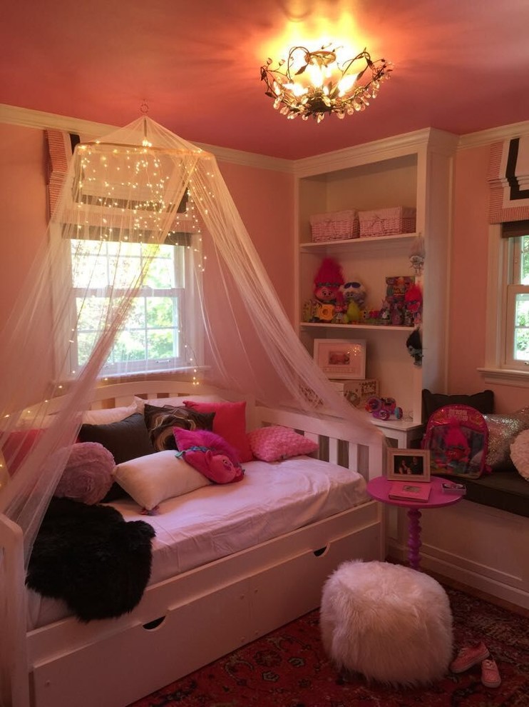 Réalisation d'une petite chambre d'enfant de 4 à 10 ans bohème avec un mur rose et un sol en bois brun.