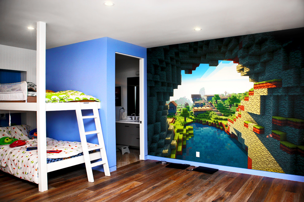 Réalisation d'une grande chambre d'enfant de 4 à 10 ans design avec un mur multicolore et un sol en bois brun.