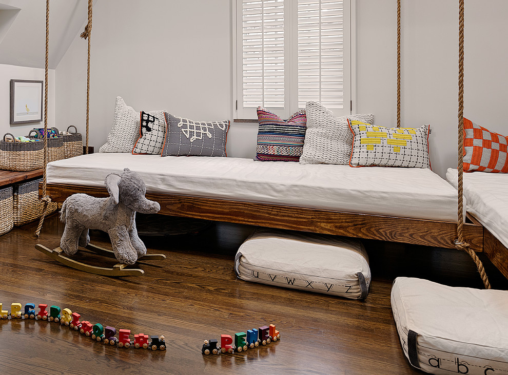 Ispirazione per una cameretta per bambini da 1 a 3 anni tradizionale di medie dimensioni con pareti bianche e pavimento in legno massello medio