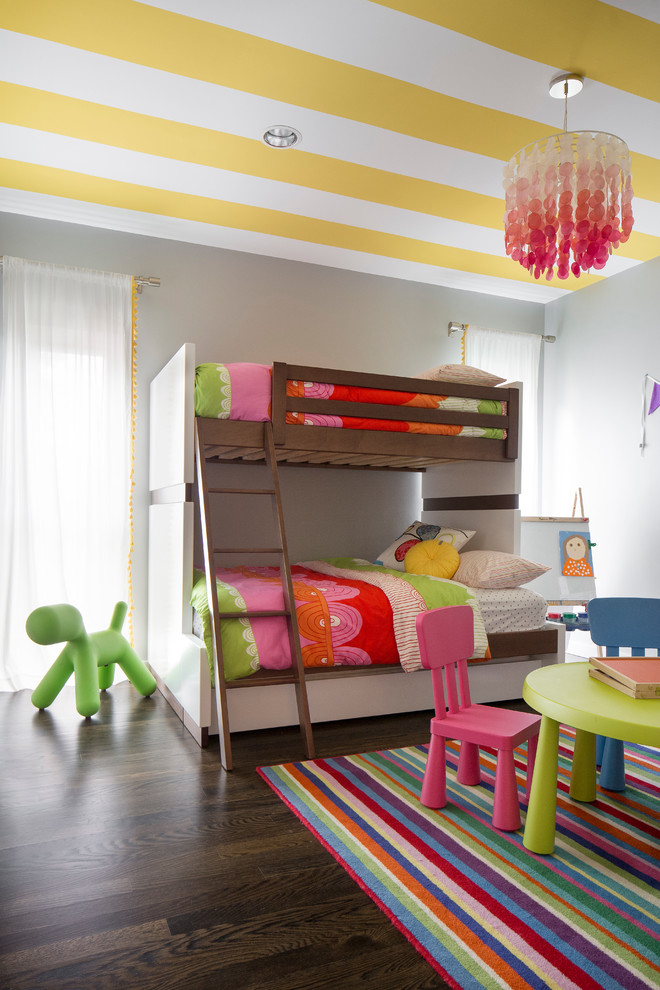 Inspiration för ett mellanstort funkis flickrum kombinerat med sovrum och för 4-10-åringar, med grå väggar och mörkt trägolv