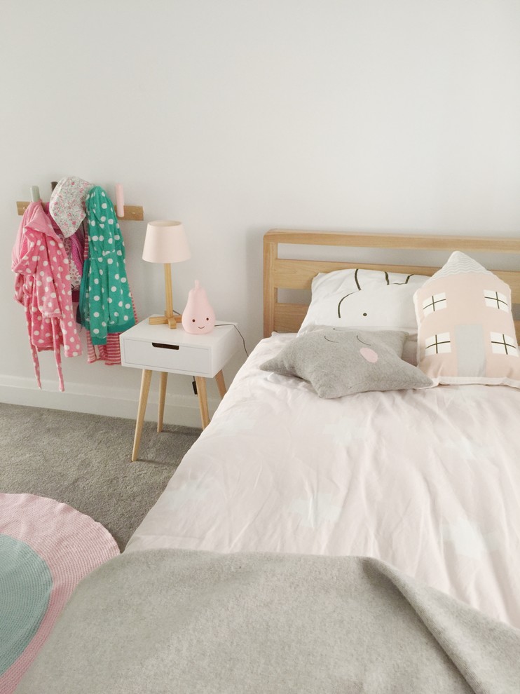 Inspiration for a mid-sized scandinavian girl carpeted kids' room remodel in Sydney with pink walls