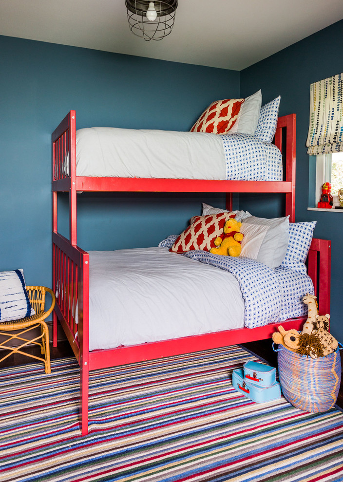 На фото: нейтральная детская в морском стиле с спальным местом, синими стенами и темным паркетным полом для двоих детей с