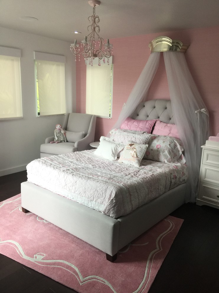 Inredning av ett modernt mellanstort flickrum kombinerat med sovrum och för 4-10-åringar, med rosa väggar, mörkt trägolv och brunt golv