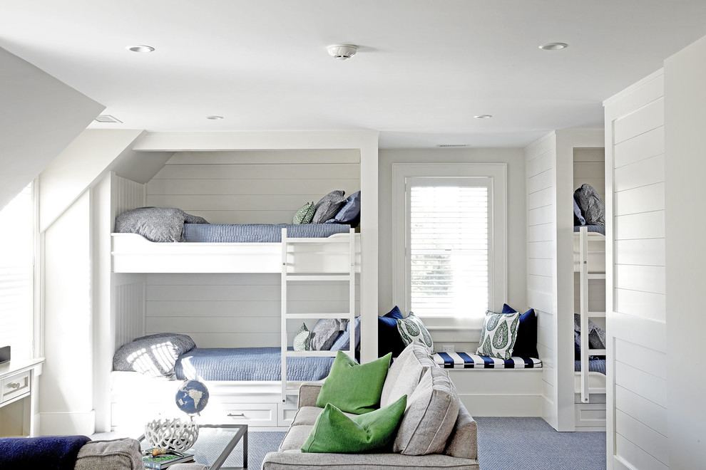 Maritim inredning av ett könsneutralt barnrum kombinerat med sovrum, med vita väggar, heltäckningsmatta och blått golv