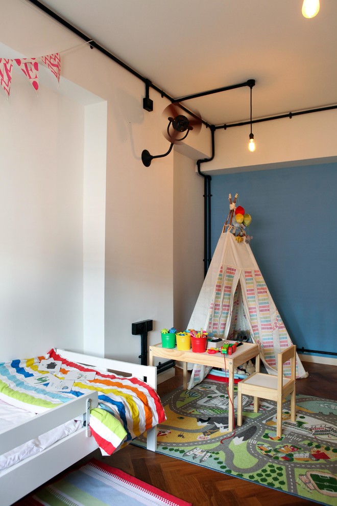 Esempio di una cameretta per bambini industriale con pareti blu, pavimento in legno massello medio e pavimento marrone