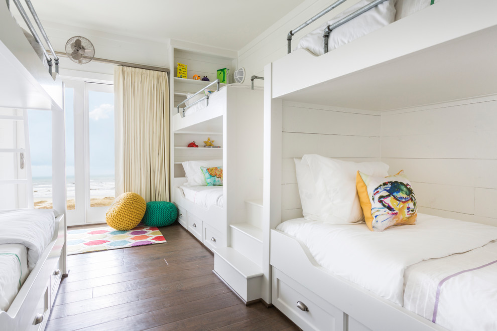 Idéer för ett maritimt könsneutralt barnrum kombinerat med sovrum, med vita väggar och mörkt trägolv