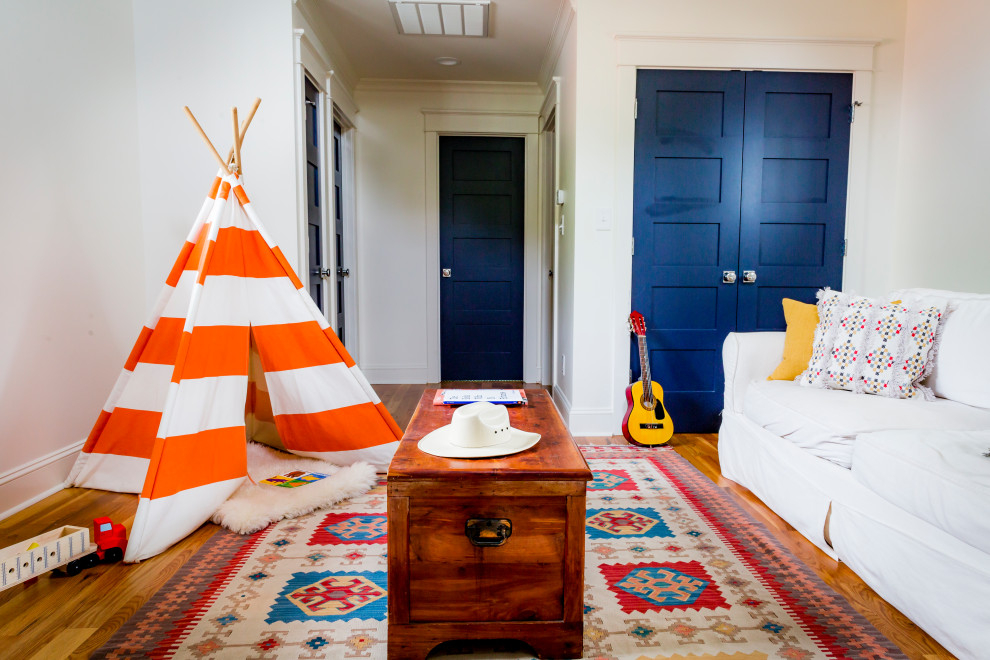 Esempio di una cameretta per bambini da 4 a 10 anni american style con pareti bianche, parquet chiaro e pavimento marrone