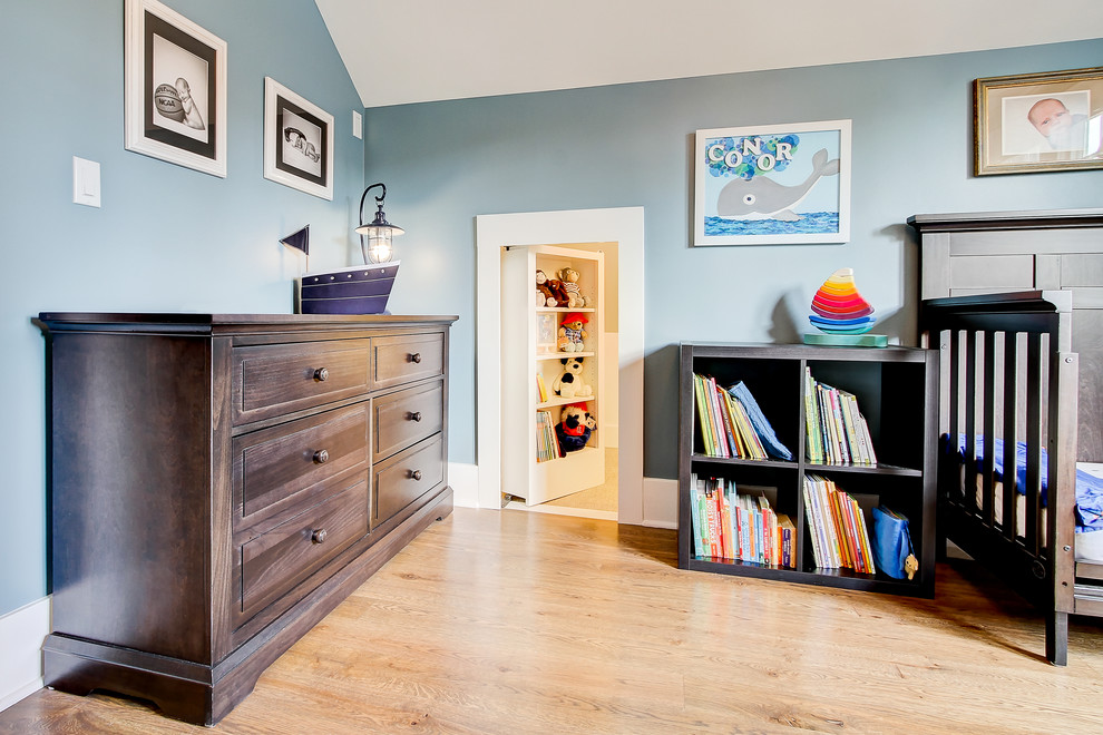 Idée de décoration pour une chambre d'enfant de 1 à 3 ans craftsman de taille moyenne avec un mur bleu et un sol en bois brun.