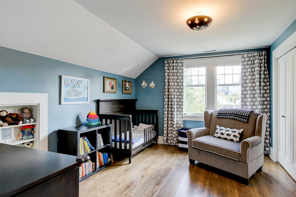 Idéer för ett mellanstort amerikanskt könsneutralt småbarnsrum kombinerat med sovrum, med blå väggar och mellanmörkt trägolv